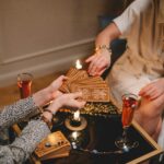 Two women engaged in a mystical tarot card reading session in a cozy indoor setting.